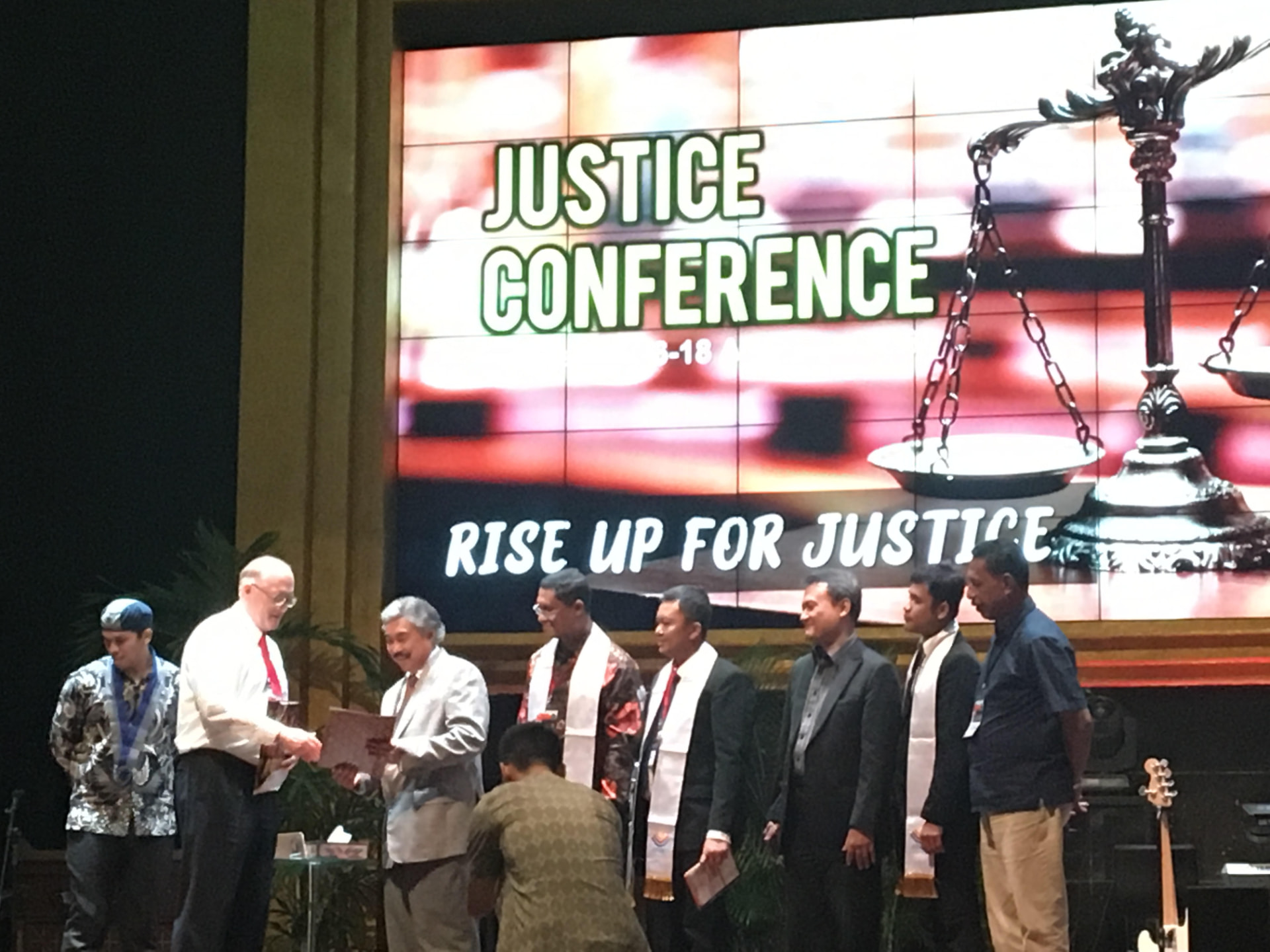 Patrick Talbot on stage with a Supreme Court Justice of Indonesia at the Rise Up For Justice conference.